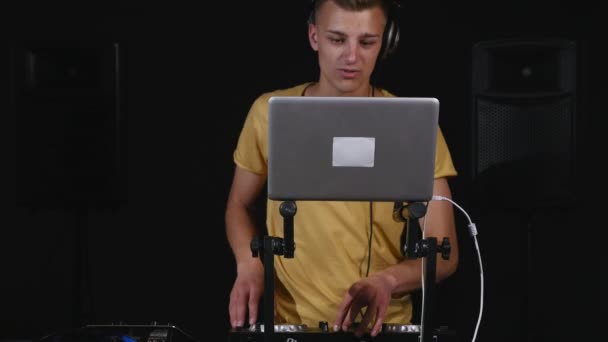 DJ налаштовує обладнання і дивиться на ноутбук — стокове відео