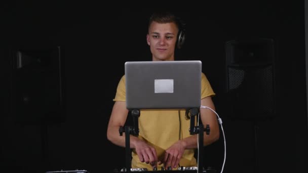 DJ регулирует оборудование и смотрит на ноутбук — стоковое видео