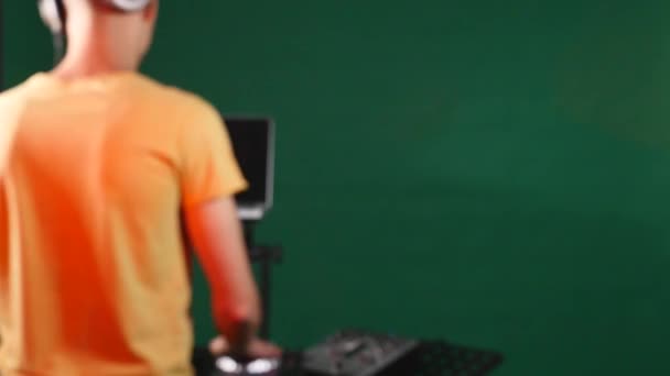 DJ dietro la sua attrezzatura, dal retro, con fuori fuoco — Video Stock