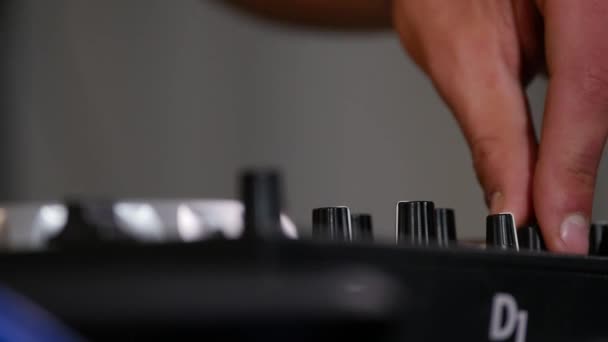 Primer plano de imágenes de un artista de música masculina manos empujando almohadillas y arañazos en un escritorio de control, DJ mezcla de música — Vídeos de Stock