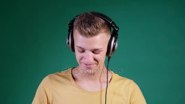DJ dançando em fones de ouvido no fundo verde — Vídeo de Stock