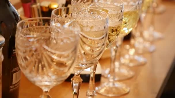 Ряд бокалов, наполненных шампанским, выстроены в ряд, готовые к подаче — стоковое видео