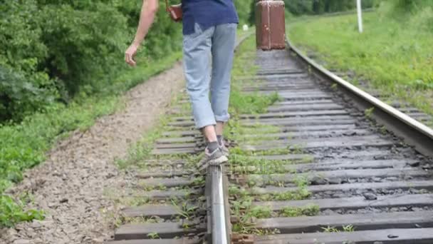 Un joven con una maleta en la línea ferroviaria. Tren pierde en una gran ciudad, un joven va a perderse en la gran ciudad — Vídeos de Stock