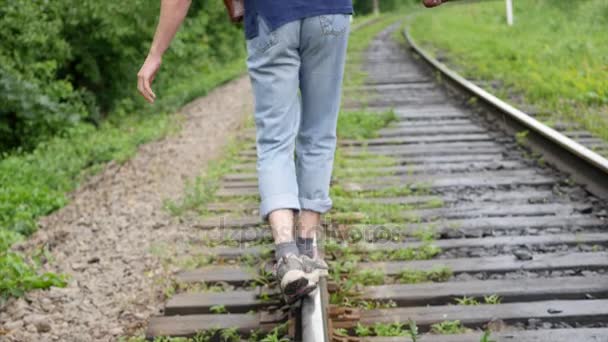 Mladý muž s kufrem na železniční trati. Vlak ztratí ve velkém městě, mladý muž jde ztratit se ve velkoměstě — Stock video