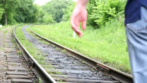 Ένας νεαρός άνδρας σε μια σιδηροδρομική γραμμή — Αρχείο Βίντεο