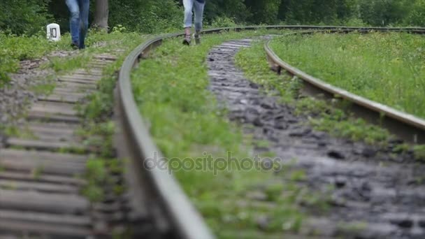 Nohy dvou mužů běží na železniční trať — Stock video