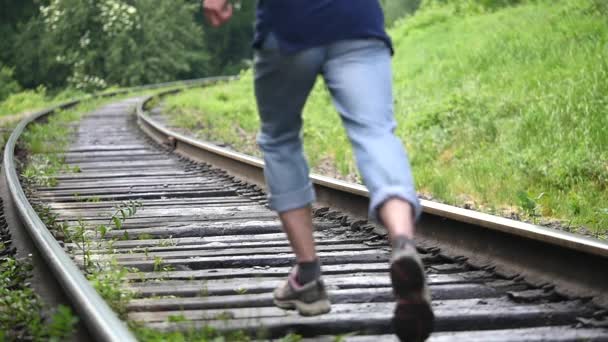 Beine Männer laufen auf Bahngleisen. Zeitlupe — Stockvideo