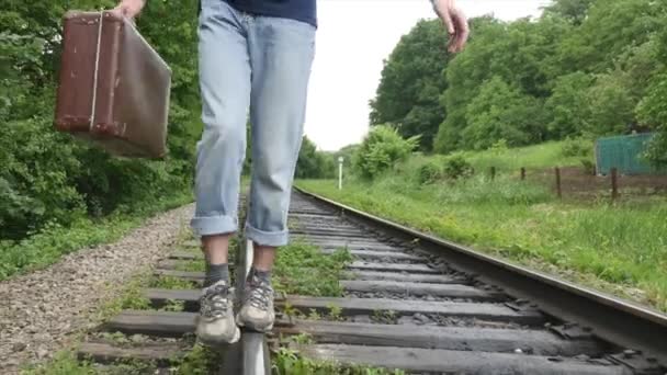 Een jonge man met een koffer op de spoorlijn. Trein verliezen in een grote stad, een jonge man gaat om in te verdwalen in de grote stad — Stockvideo