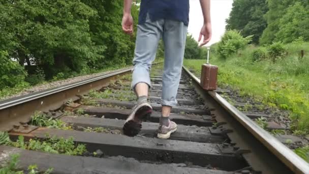 La mano del hombre con la maleta caminando por la vía férrea — Vídeos de Stock