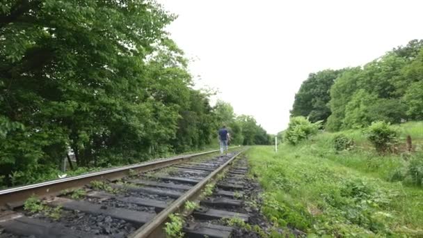 En ung man på en järnvägslinje — Stockvideo