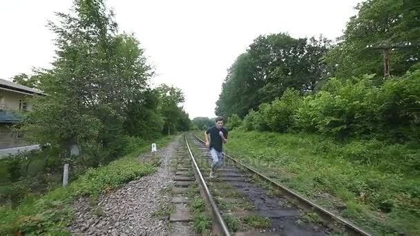 Mężczyźni nogi uruchomiona na torach kolejowych. powolne ruchy — Wideo stockowe
