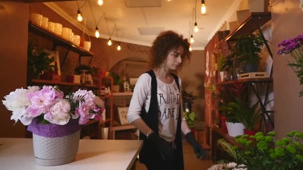 Florista prepara um buquê de flores para venda aos clientes apaixonados. Design floral, artes florais, criação de arranjos florais a partir de flores cortadas, folhagens, ervas, gramíneas ornamentais, materiais vegetais — Vídeo de Stock