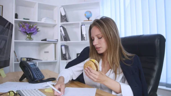 Meşgul kadın hamburger yerken Evet — Stok fotoğraf