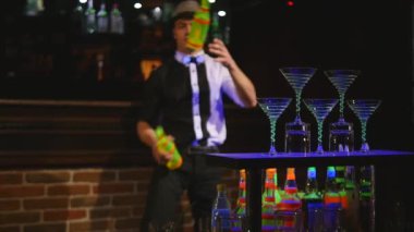 İki şişe hokkabazlık barmen tarafından gerçekleştirilen akrobatik gösterisi. Bar arka plan. ağır çekim. seçici odak