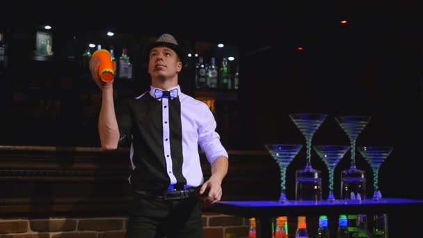 Acrobatische show uitgevoerd door barman jongleren fles. Bar achtergrond. Slow motion — Stockvideo