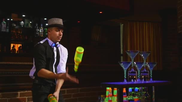 Acrobatic show performed by barman juggling two bottles. bar background. slow motion — Stock Video