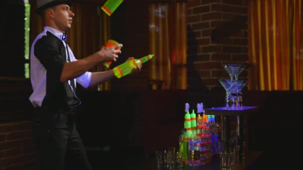 Espectáculo acrobático realizado por barman haciendo malabares con dos botellas y Beaker para mezclar. fondo de barra — Vídeos de Stock