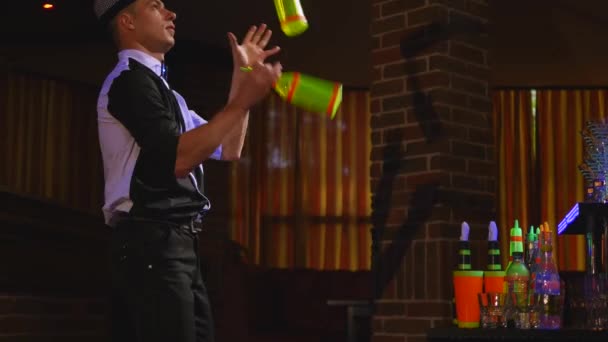 Akrobatische Show von Barkeeper, der mit drei Flaschen jongliert. Nahaufnahme — Stockvideo