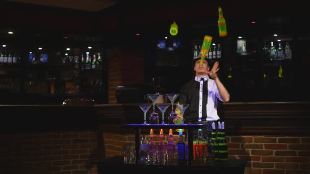 Espectáculo acrobático realizado por barman haciendo malabares con cuatro botellas. cámara lenta — Vídeo de stock