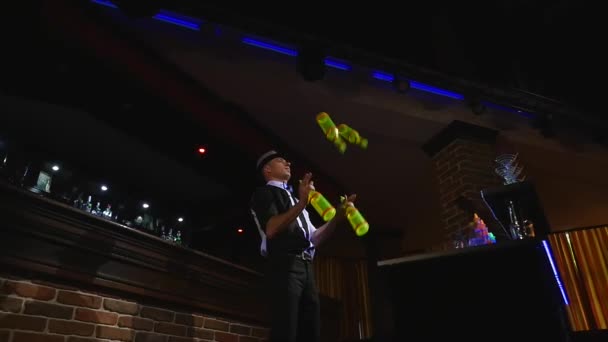 Acrobatische show uitgevoerd door barman jongleren vier flessen. Slow-motion. Onderaanzicht — Stockvideo