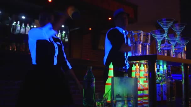 Barmann-Show. Zwei Barkeeper jonglieren mit Flaschen und Bechern zum Mischen. Nahaufnahme — Stockvideo