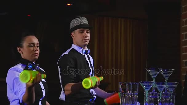 Barman show. Two barmen juggle bottles and Beaker for mixing . slow motion — Stock Video
