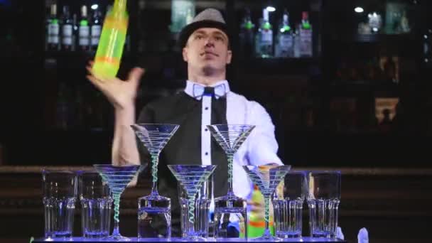 Акробатическое шоу в исполнении бармена, жонглирующего тремя бутылками. фон бара — стоковое видео