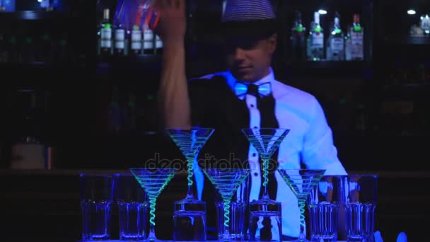 Мужчина-бармен жонглирует бутылкой и делает коктейль. Барменское шоу, четкие кадры, профессиональный бармен — стоковое видео