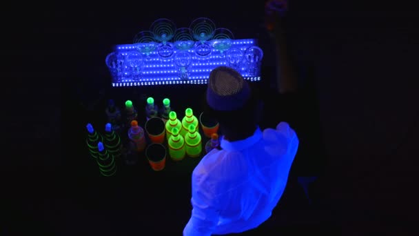 Акробатическое шоу в исполнении бармена, жонглирующего бутылками и делающего коктейли. вид сверху — стоковое видео