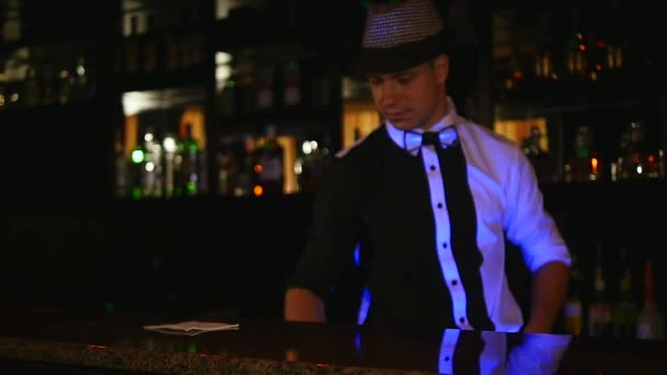 SLOW MOTION: Close up of a bartender putting a cocktail glass onto the wooden bar — Stock Video