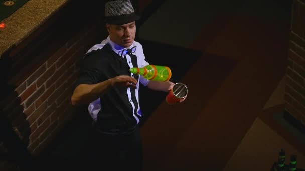 Akrobatisk show utförs av bartendern jonglering flaska och bägare för blandning. bar bakgrund. slowmotion. ovanifrån — Stockvideo