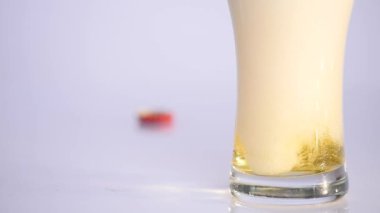 Bardak beyaz arka plan üzerinde boşalma bira. yakın çekim