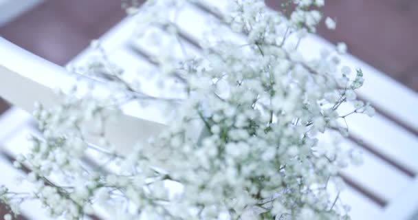 Білі весільні стільці з квітами. Церемонія весілля на відкритому повітрі. Весілля в саду — стокове відео