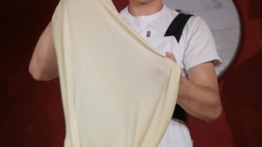 eller genç adam iplik ve havadaki Restoran mutfağında iki elle hamur kusuyor