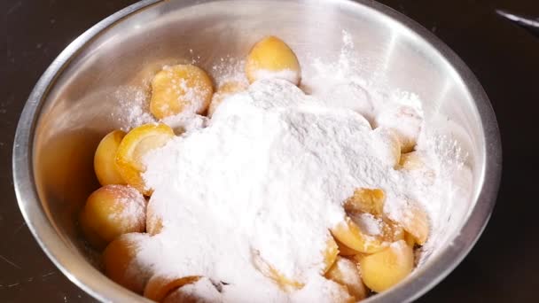 Das Mehl fällt in einen Teller mit Aprikosen und Zucker — Stockvideo
