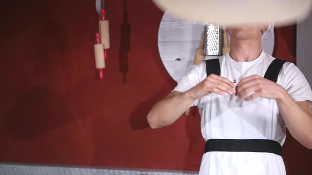 Jeune homme filant et jetant de la pâte en l'air avec deux mains dans la cuisine du restaurant — Video