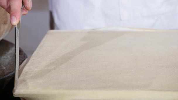 Hand cuts dough for baking knife, dough lying on table — Stock Video