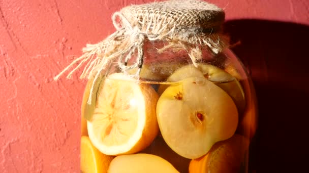 Pot met compote van appel en citroen op een rode achtergrond — Stockvideo