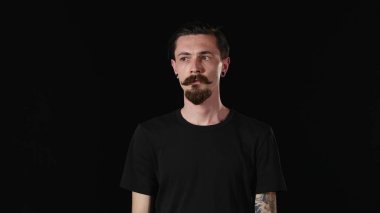 Sakallı genç adam kamera ve Corrects, bang arıyor