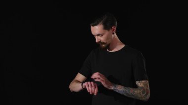 sakallı adam bir saatini ayarlar