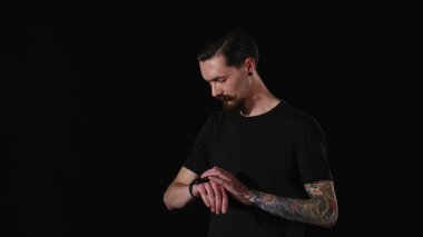 sakallı adam bir saatini ayarlar