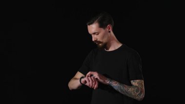 sakallı adam bir saatini ayarlar