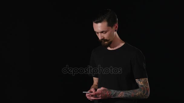 Um tipo barbudo tira o telefone do bolso e escreve uma mensagem. — Vídeo de Stock