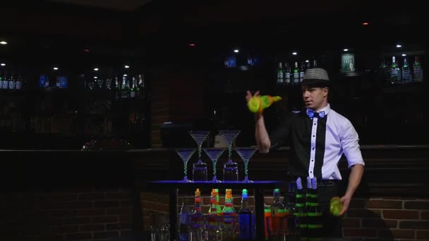 Acrobatic show performed by barman juggling two bottles. bar background. slow motion — Stock Video