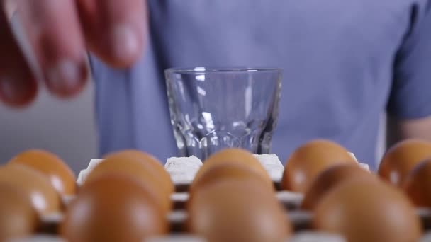 Männerhand zerbricht das Ei in ein Glas, Zeitlupe — Stockvideo