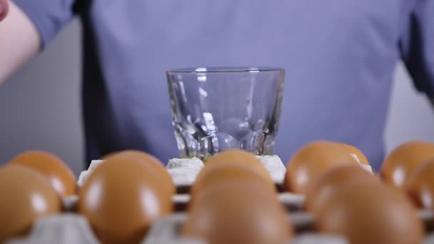 Mans hand breaks the egg into a glass, slow motion — Stock Video