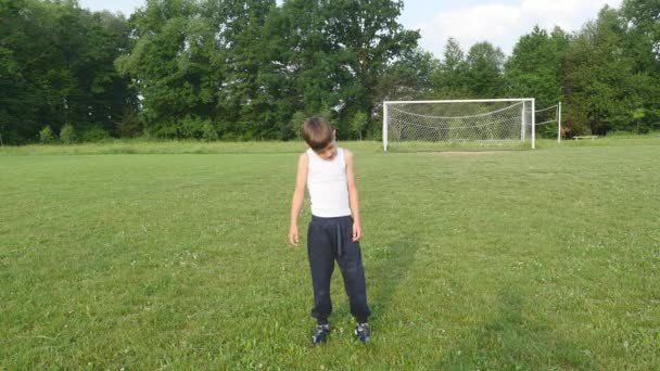 Мальчик занимается гимнастикой на футбольном поле — стоковое видео