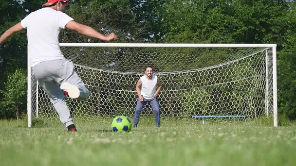 Padre e hijo jugando al fútbol en el fútbol en el día — Vídeos de Stock