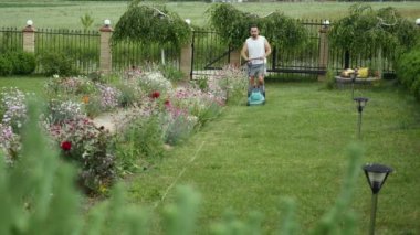 Adam bahçesinde biçme makinesi ile Bahçe çim biçme