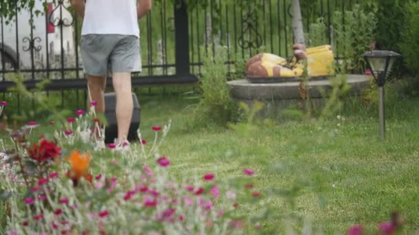 Man tuin gazon maaien met maaier machine in tuin — Stockvideo